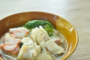 Chinese dumpling topping slice red barbecue pork with clear soup on bowl