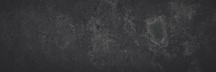 Fototapeta premium Dark wide panoramic background. Peeling paint on a concrete wall. Faded dark texture of old cracked flaking paint. Weathered rough painted surface with patterns of cracks. Shaded background for design