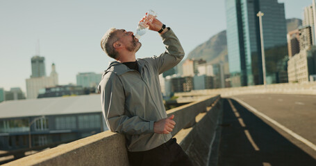 Fitness, drinking water and man in city for wellness, health and hydration in town for running....