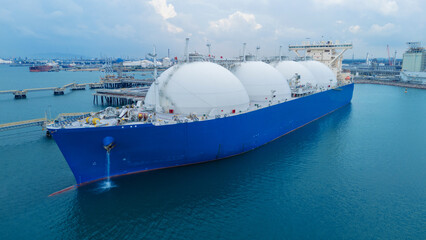 LNG (Liquified Natural Gas) tanker anchored in Gas terminal gas tanks for storage. Oil Crude Gas Tanker Ship. LPG at Tanker Bay Petroleum Chemical or Methane freighter export import transportation
