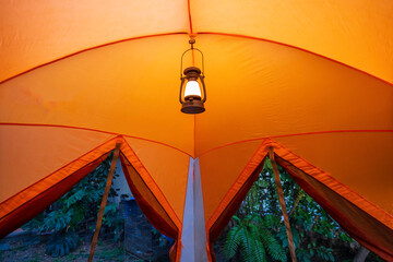 antique lamp Light inside the camping tent at night in the pitch dark forest, selective focus, soft...