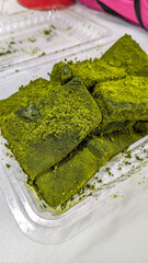 Japanese warabi mochi dessert topped with green matcha powder