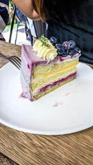 Forks poking on a slice of blueberry cheesecake served on a white plate