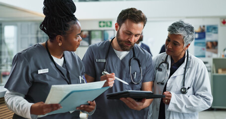 Obraz premium Healthcare, tablet and group with documents, hospital and diversity of staff, reading and collaboration. Teamwork, professional and people with paperwork, women and doctor with intern and clinic