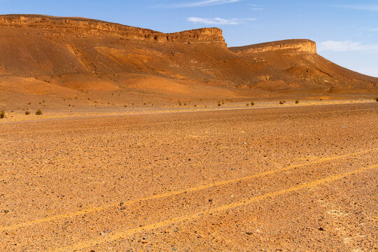 Dry stone desert and lonely table mountain in the background. Morocco

