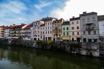 photography of colourfull buildings in front of the river Ljubljanica in Ljubljana, Slovenia during a foggy morning