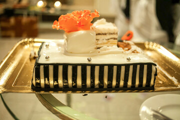 A cake with orange flowers on it sits on a table.