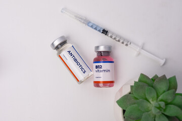 A syringe and two vials, one is Antibiotics and the other is B12 Vitamin on the doctor's desk