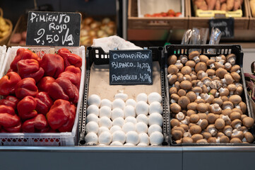 Champiñones y pimiento rojo a la venta en un puesto de fruteria en un mercado de barrio.