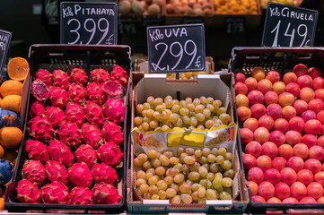 Variedades de fruta, pitahaya y uva blanca a la venta en un mercado de barrio.