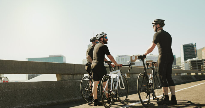 Bicycle, city and conversation with sports people outdoor together for hobby, recreation or team building. Break, cycling and partnership with athlete friends in urban town for exercise or fitness - Powered by Adobe