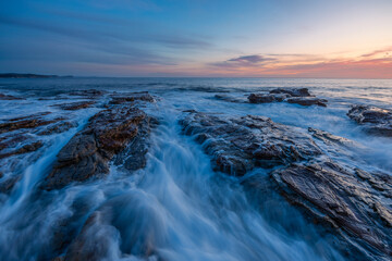 Dawn view on the rocky shore coastline.