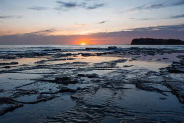 Sunrise view from the rocky beach shore.