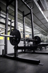 Gym machine with a barbell and weight plates, ideal for strength training and muscle building....
