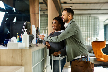 A young African American couple happily checking into their hotel, excited for their upcoming...