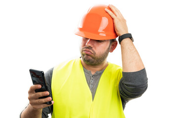 Builder looking at smartphone screen with confused expression