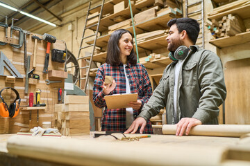 Lumberyard teamwork with experienced worker assisting apprentice