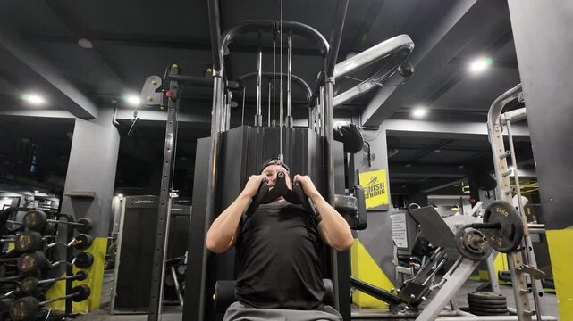 Handsome Man Performing Close-Grip Front Lat Pulldown on Gym Machine, Focusing on Back Muscles and Back Development During Workout