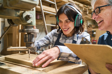 Young apprentice and mentor working together in a lumber workshop