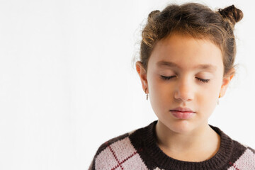 Young girl with closed eyes in a peaceful expression in a studio setting, copy space