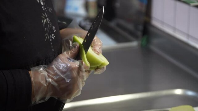 ハヤトウリの皮をむく女性