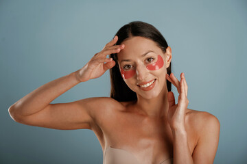 Fototapeta premium Time for beauty procedures, red patches under eyes. Young woman is in the studio against background