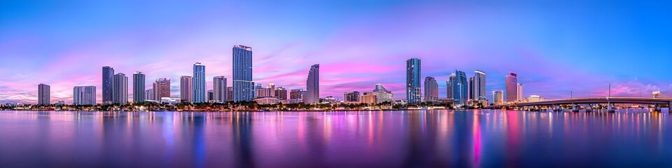 Fototapeta premium A vibrant cityscape of Florida at dusk, showcasing the iconic landmark with high-rise buildings . The sky is painted with hues of blue and purple as the sun sets behind them, casting long shadows on