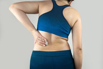 Woman's back problems. Chronic back pain. Woman holding her lower back. Back pain, sore kidneys