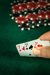 Poker cards with combinations of three of a kind or set in the hand of an gambling player. Winning combination in a game in a poker club on a green table. The concept of luck or fortune in gambling