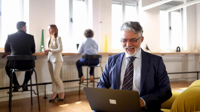 Mature businessman working on a laptop at the lobby of his company