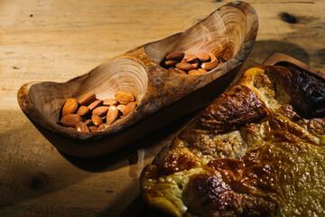 baked almond cake against the background of wooden accessories and autumn leaves