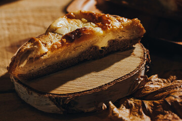 baked almond cake against the background of wooden accessories and autumn leaves