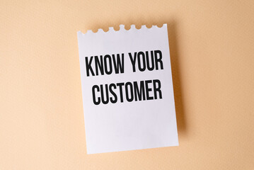 Know Your Customer text on white sticky note on yellow background.