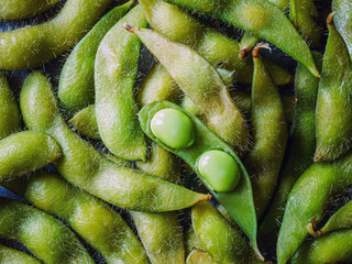 Close-up of boiled Green soybeans, Many fresh Green soybeans as background, top view