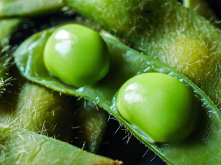 Close-up of boiled Green soybeans, Many fresh Green soybeans as background, top view