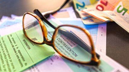 Avis de contravention reçu avec lunettes et billets de banque