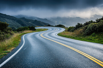 A winding road snakes through misty hills under a dramatic sky, creating an atmospheric scene of solitude and adventure.