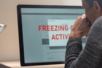 Confused young man having problem with online order payment. A man in deep thought as he examines a frozen screen, symbolizing challenges in account management and the importance of troubleshooting