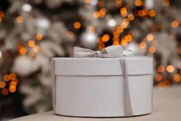 White gift box. Against the background of New Year's bokeh. New Year. Close-up. Copyspace