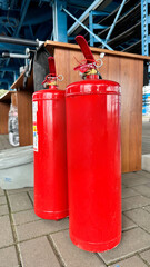 На фотографии огнетушитель для тушение огня спасателями или людьми он красного цвета и тяжёлый находится на улице для тушения пожара  ..