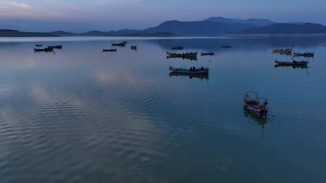 Khanpur Dam Lake Aerial Sunset View, Pakistan. Boats in water and Mountainsd on Background