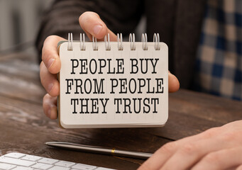 People Buy From People They Trust. Businessman holding a card with a message text written