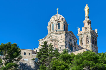 A beautiful shot of the Notre-Dame de la Garde basilica in Marseille, highlighting its golden...