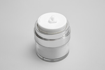 Pressure vacuum cream dispenser, with gray background,, soft focus close up