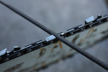 Chainsaw chain sharpening with a special round file, soft focus close up