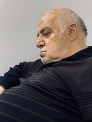 Eighty-year-old grandfather falls asleep in front of the TV after dinner 