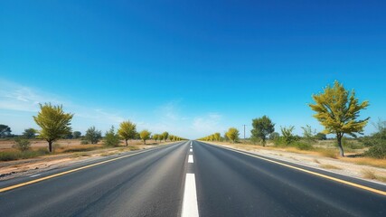 Naklejka premium Asphalt road stretching into the distance under a vast blue sky with scattered green trees on either side, serene atmosphere, open space, winding road