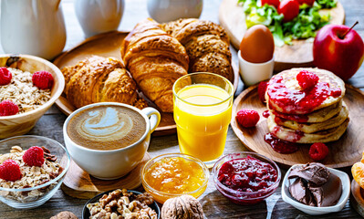 Breakfast served with coffee, orange juice, pancakes, croissant