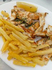 Grilled Chicken and French Fries Served on a Sunny Terrace in Málaga