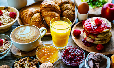 Breakfast served with coffee, orange juice, pancakes, croissant
